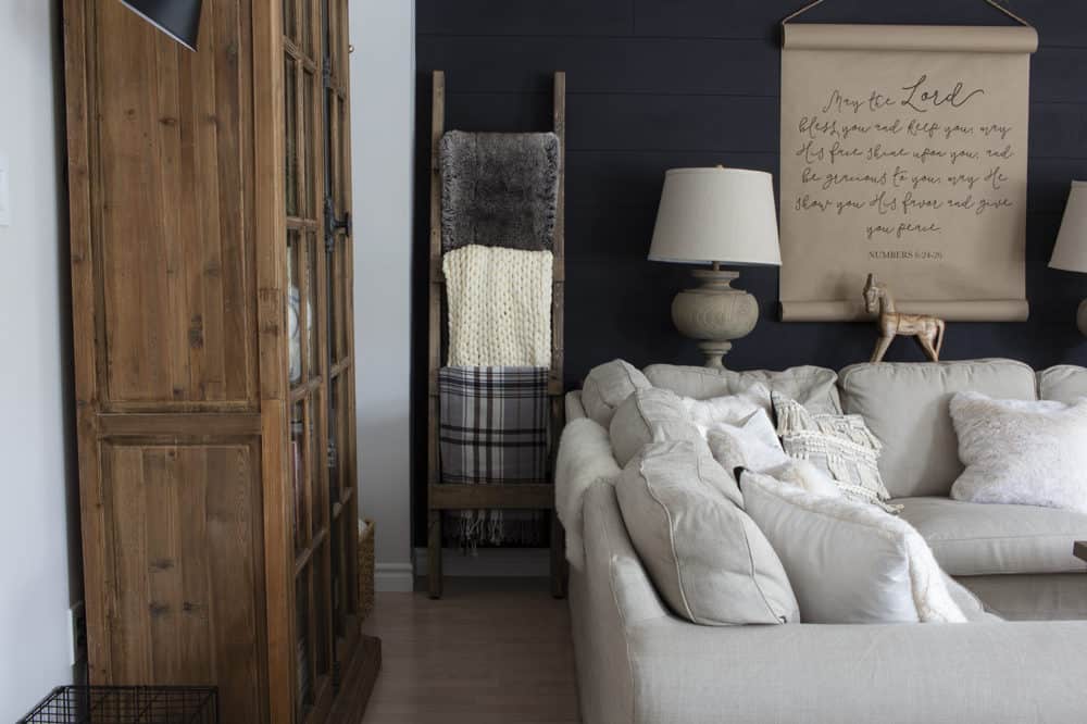 blanket ladder leaned against black shiplap wall