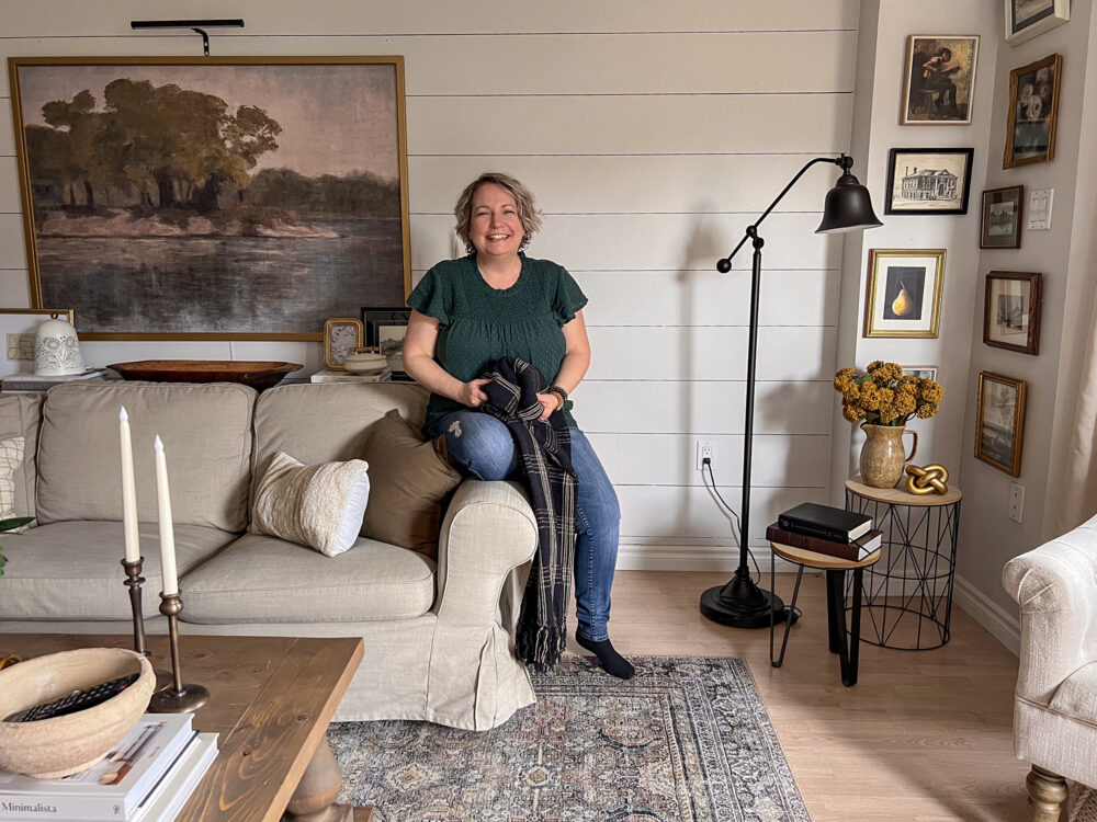 shannon sitting on couch in green blouse to illustrate calm happy spaces challenge