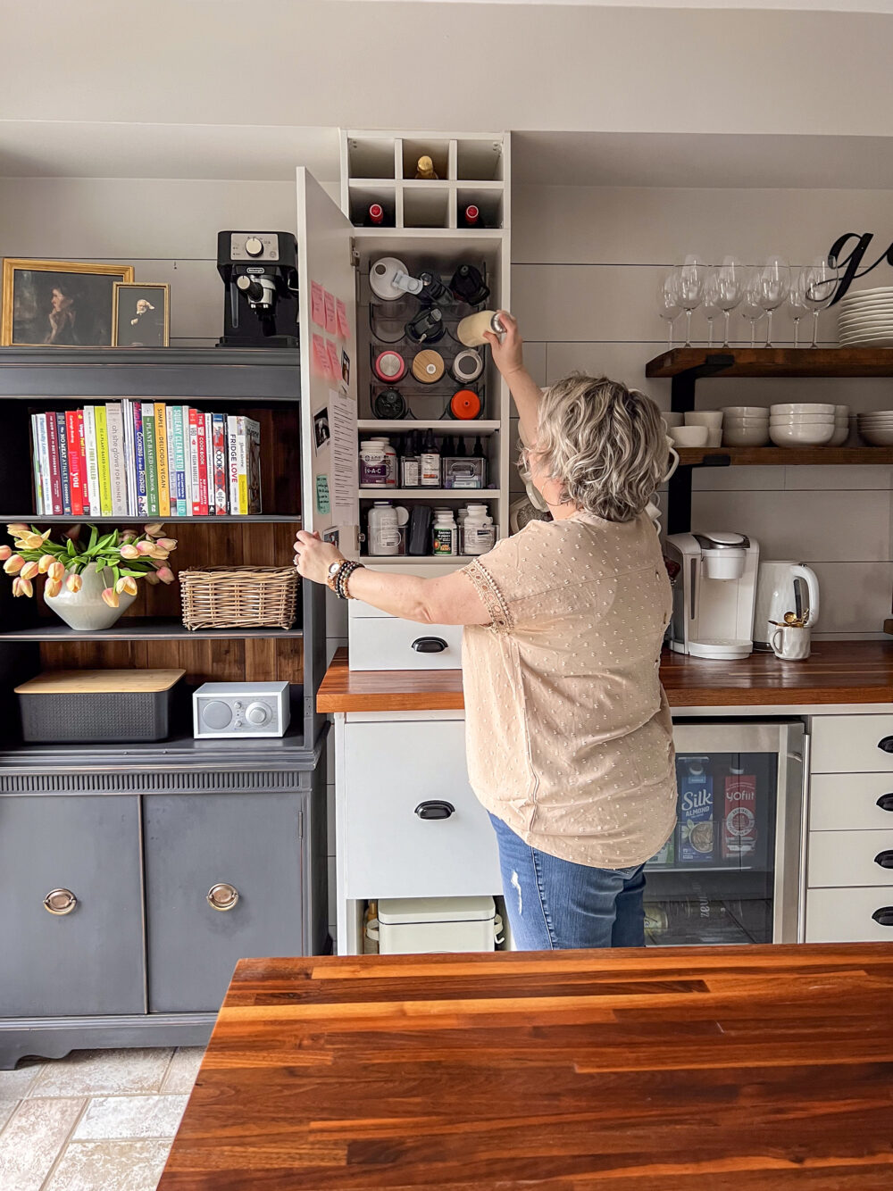 shannon putting water bottle in cupboard to illustrate home organizing tips